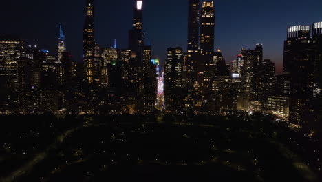 Aerial-view-over-the-Central-park,-toward-supertall-skyscrapers-of-Billionaires'-Row,-night-in-New-York,-USA