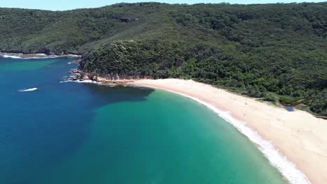 Drone-aerial-shot-of-Maitland-Bay-Bouddi-National-Park-bushaldn-coastline-ocean-beach-swimming-holiday-spot-tourism-travel-NSW-Central-Coast-Australia-4K