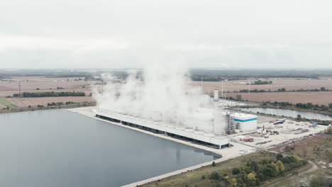 Natural-Gas-Power-Plant-Beside-a-Cooling-Pond-in-Rural-Countryside,-Aerial