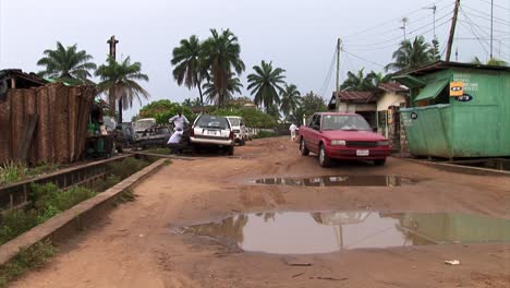 Coche-Conduciendo-A-Través-De-Grandes-Charcos-Y-Baches-Después-De-Fuertes-Lluvias-En-Nigeria
