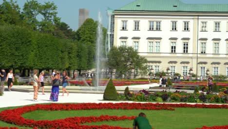 Panoramic-View-of-Beautiful-Gardens-and-Statues-of-Mirabell-Palace-with-Tourists-Walking-Around