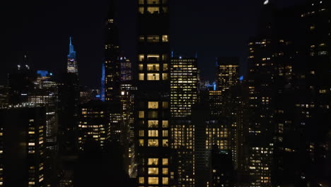 Aerial-view-around-skyscrapers-in-Midtown,-Manhattan,-night-in-New-York,-USA
