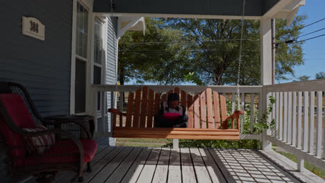 A-serene-and-picturesque-stock-footage-clip-showcasing-a-smooth-camera-motion-ascending-the-stairs-of-a-front-porch,-leading-to-a-charming-scene-of-a-little-girl-engrossed-in-a-tablet