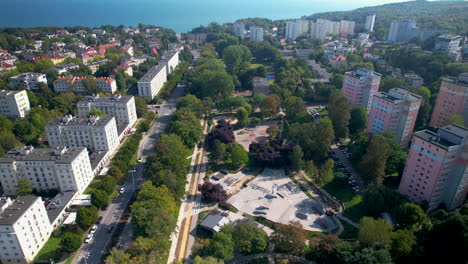 Aerial-establishing-view-of-Park-Centralny-lined-with-white-apartment-buildings,-Gdynia-Poland