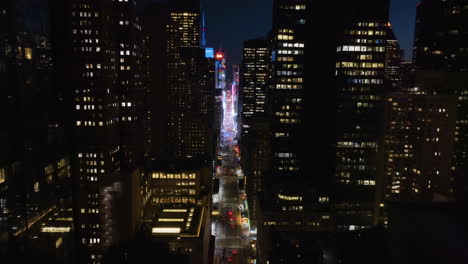 Aerial-view-backwards-through-the-7th-avenue,-away-from-the-Times-square,-night-in-NY,-USA