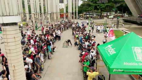 Go-Skateboarding-day,-people-gathering-to-watch-skateboarders-doing-tricks