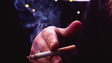 Primer-Plano-De-La-Luz-De-Fondo:-Un-Hombre-Con-Barba-Roja-Fuma-Un-Cigarrillo-En-Cámara-Lenta,-Fuma
