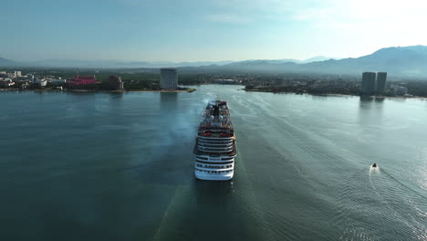 Aerial-view-following-a-cruise-ship-moving-toward-Puerto-Vallarta,-in-sunny-Mexico