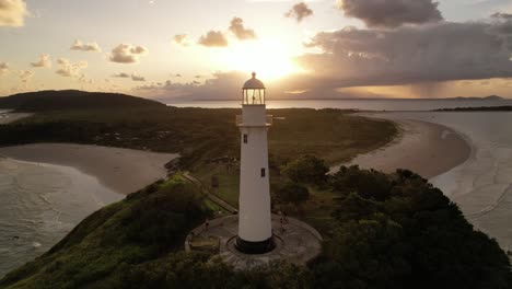 Aerial-view-at-sunset-of-the-Farol-das-Conchas-lighthouse-and-beaches-of-Ilha-do-Mel,-Paranaguá,-Paraná,-South,-Brazil