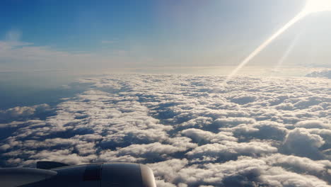 Un-Avión-Volando-Sobre-Las-Nubes-En-Un-Día-Soleado