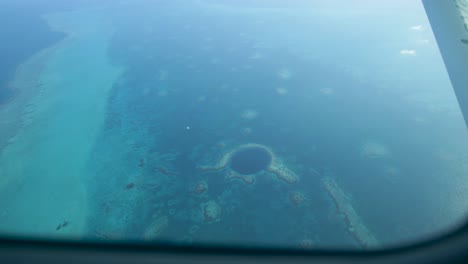 Aerial-view-captures-the-stunning-beauty-of-the-Great-Blue-Hole,-a-natural-wonder-in-a-sea-of-azure