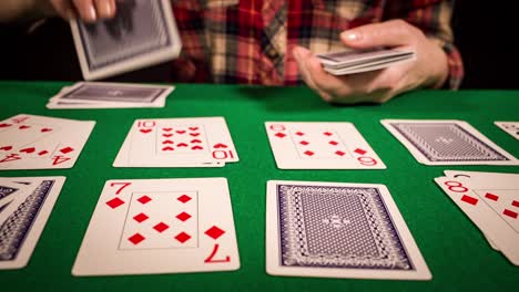 Close-up-of-female-hands-holding-cards-and-playing-solitaire
