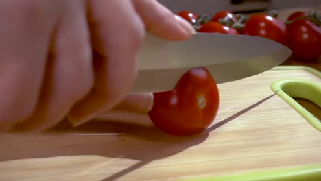 Knife-cuts-tomato-on-wooden-board-Slow-motion-with-rotation-tracking-shot.