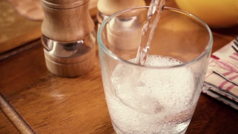 Mineral-water-pouring-into-a-glass,-the-morning-Breakfast,-Slow-motion-with-rotation-tracking-shot.