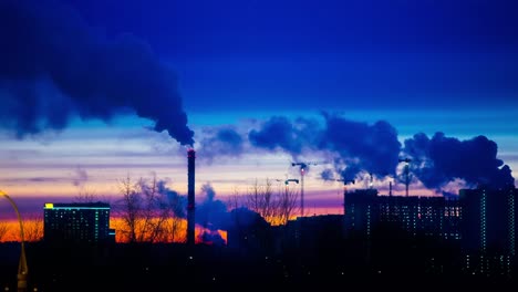 Moderne-Stadt-Am-Abend-Bei-Sonnenuntergang.-Rauch-Kommt-Aus-Den-Rohren.