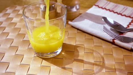 Orange-juice-pouring-into-a-glass,-the-morning-Breakfast.-Slow-motion-with-rotation-tracking-shot.