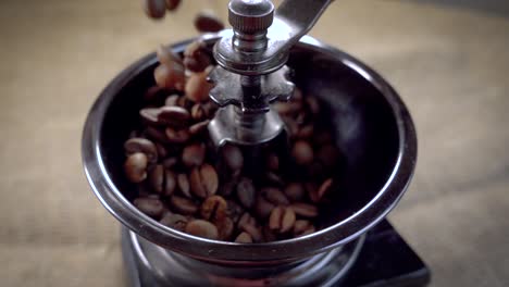 Coffee-beans-fall-in-the-old-grinder.-Slow-motion-with-rotation-tracking-shot.