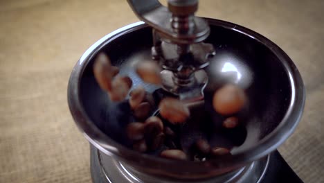 Coffee-beans-fall-in-the-old-grinder.-Slow-motion-with-rotation-tracking-shot.