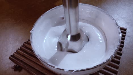 Beaten-eggs-with-sugar-using-a-mixer.-Slow-motion-with-rotation-tracking-shot.