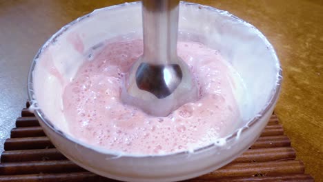 Beaten-eggs-with-sugar-and-strawberries-using-a-mixer.Slow-motion-with-rotation-tracking-shot.