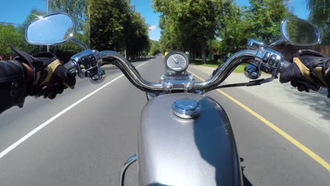 Riding-a-motorcycle.-Biker-rides-on-the-road-with-a-first-person.