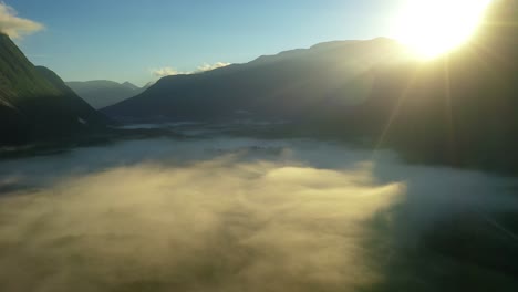 Morning-mist-over-the-valley-among-the-mountains-in-the-sunlight.-Fog-and-Beautiful-nature-of-Norway-aerial-footage.