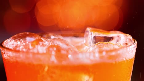 Glass-of-soft-drink.-Ice-soft-drink-with-splashing-bubbles-slow-motion-on-a-blurry-light-,blurry-background.