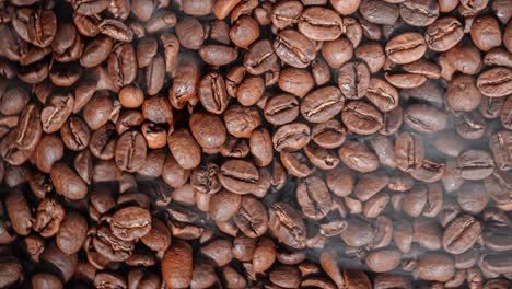Close-up-of-seeds-of-coffee.-Fragrant-coffee-beans-are-roasted-smoke-comes-from-coffee-beans.