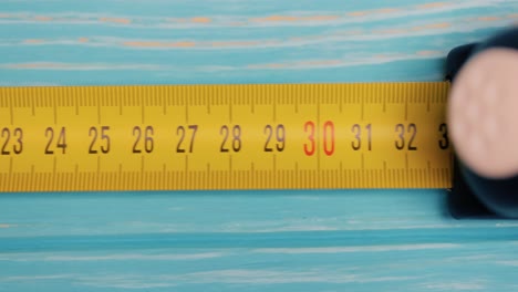 Roll-of-measuring-tape-in-motion-macro