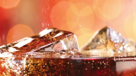 Glass-of-cola.-Ice-cola-with-splashing-bubbles-slow-motion-on-a-blurry-light-,blurry-background.