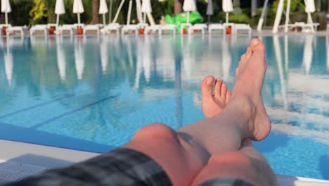 Männerfüße-Auf-Dem-Hintergrund-Des-Schwimmbades,-Entspannen-Sie-Sich-Im-Urlaub