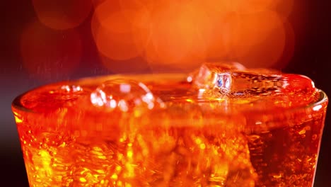 Glass-of-soft-drink.-Ice-soft-drink-with-splashing-bubbles-slow-motion-on-a-blurry-light-,blurry-background.