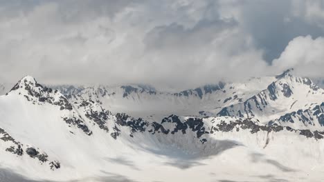 Vuelo-Aéreo-A-Través-De-Nubes-Montañosas-Sobre-Hermosos-Picos-Nevados-De-Montañas-Y-Glaciares.