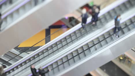 People-in-motion-in-escalators-at-the-modern-shopping-mall.-Tilt-shift-lens-shooting-with-super-shallow-depth-of-field.