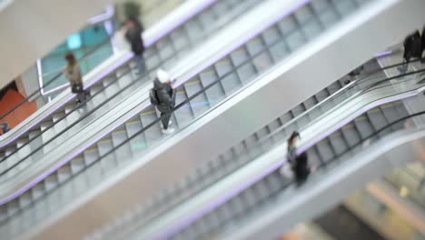 People-in-motion-in-escalators-at-the-modern-shopping-mall.-Tilt-shift-lens-shooting-with-super-shallow-depth-of-field.