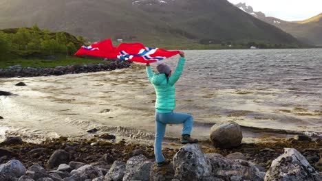 Mujer-Con-Una-Bandera-Ondeante-De-Noruega-En-El-Fondo-De-La-Naturaleza.