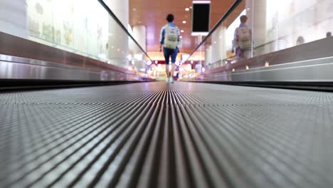 Moving-walkway-at-the-airport,-also-known-as-an-autowalk,-moving-sidewalk,-moving-pavement,-people-mover,-travolator,-or-travelator,-is-a-slow-moving-conveyor-mechanism-that-transports-people.