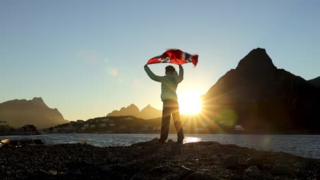 Woman-waving-the-flag-of-Norway-at-sunset