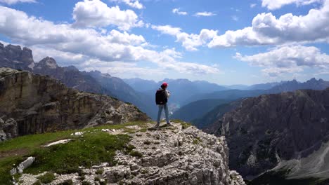 Hiker-woman-standing-up-achieving-the-top-Dolomites-Alps.