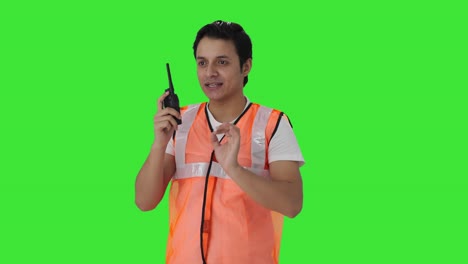 Happy-Indian-airport-worker-giving-instructions-on-walkie-talkie-Green-screen