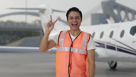 Happy-Indian-airport-ground-staff-showing-victory-sign