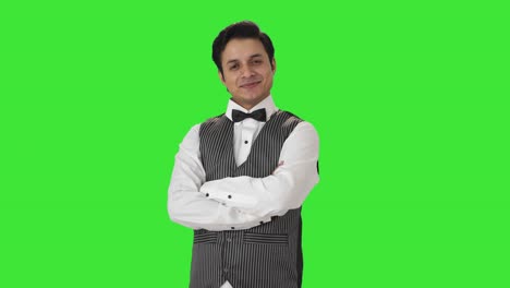 Portrait-of-Happy-Indian-waiter-standing-crossed-hands-Green-screen