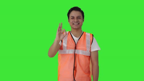Happy-Indian-airport-ground-staff-showing-Okay-sign-Green-screen