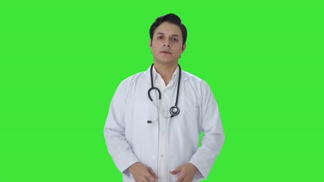 Indischer-Arzt-Legt-Stethoskop-Auf-Grünem-Bildschirm-Auf-Die-Schultern