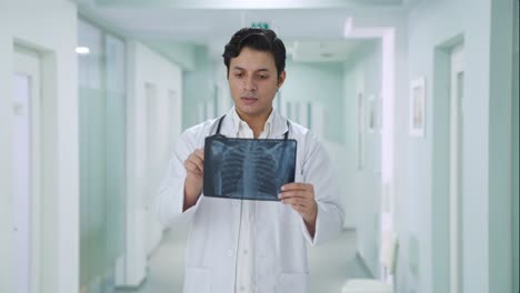 Médico-Indio-Serio-Revisando-El-Informe-De-Rayos-X