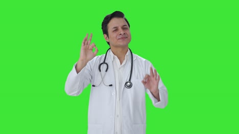 Happy-Indian-doctor-showing-okay-sign-Green-screen