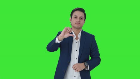 Upset-Indian-businessman-showing-thumbs-down-Green-screen