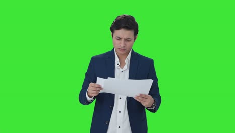 Confused-Indian-manager-checking-reports-Green-screen