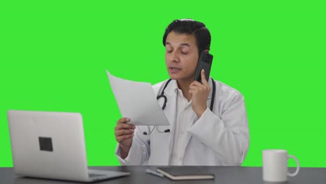 Médico-Indio-Entregando-Noticias-Al-Paciente-En-La-Pantalla-Verde-Del-Teléfono