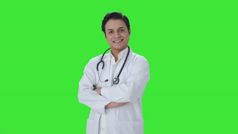 Retrato-De-Un-Feliz-Médico-Indio-De-Pie-Con-Las-Manos-Cruzadas-En-La-Pantalla-Verde